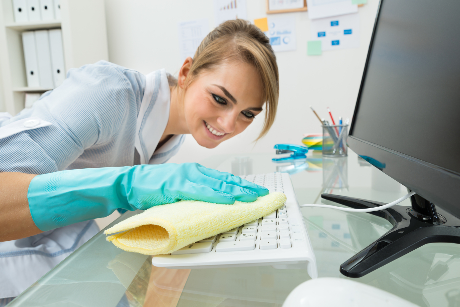 Maid Cleaning Keyboard At Desk