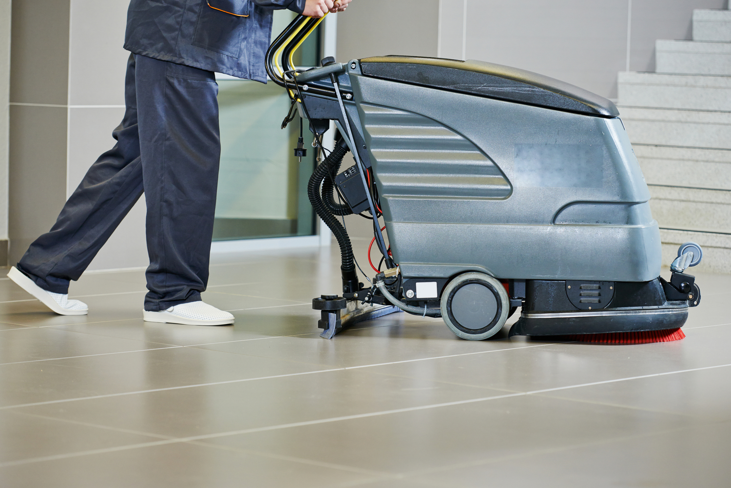 worker cleaning floor with machine